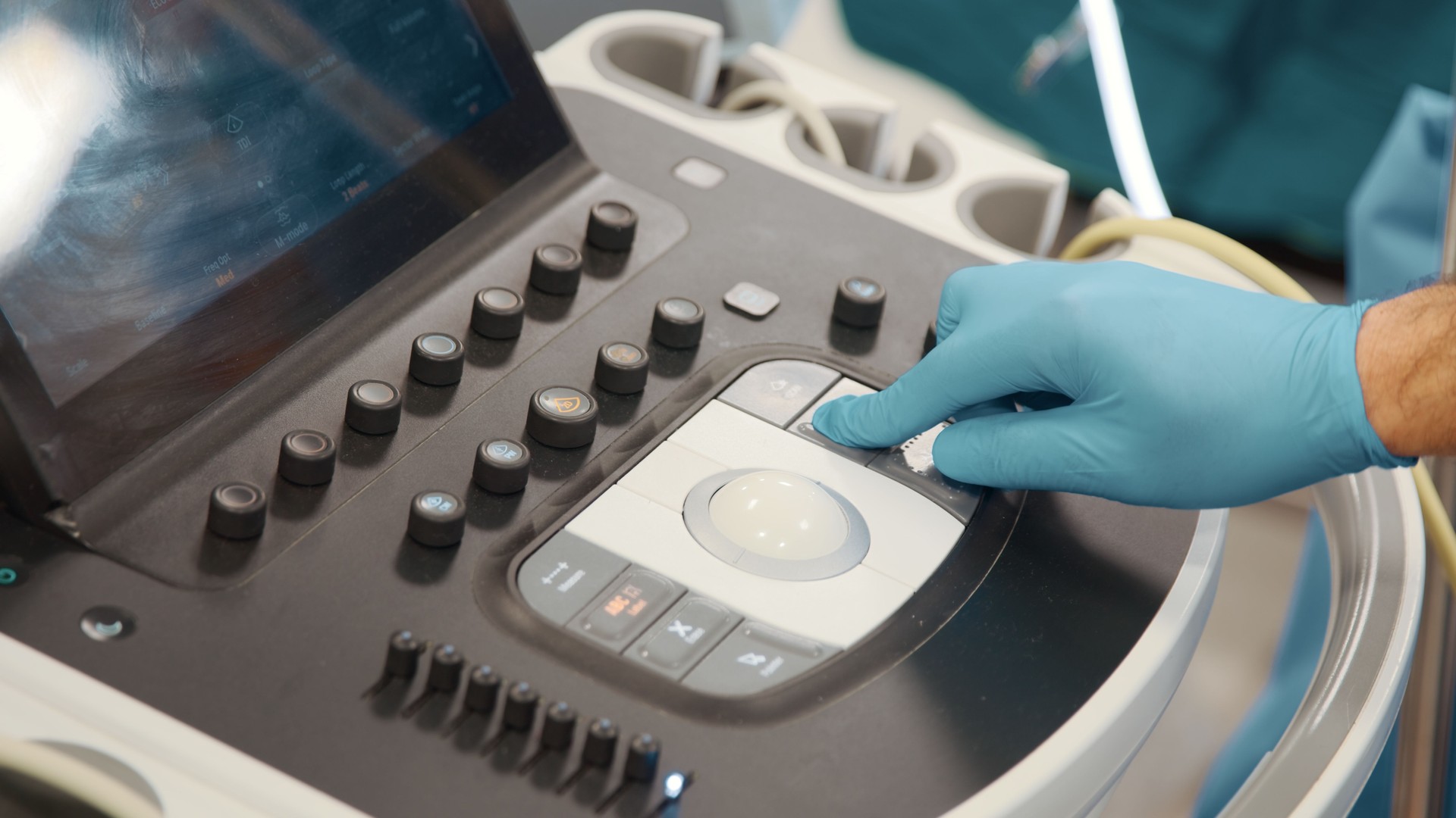 Healthcare worker selects an option on an ultrasound machine